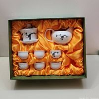 Full view of the Chinese porcelain tea set in a presentation box with golden fabric lining, showing all items included.