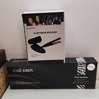 Photo of boxed José Eber flat iron and flat iron holder box stacked, showing product packaging and branding details.