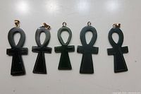 Five jade ankh pendants laid out side-by-side showing front view with bails visible on four pendants.