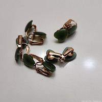 Photo of 10 jade heart clip-on earrings grouped together showing gold-tone clips and green jade stones.