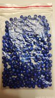 Photo of resealable plastic bag containing small round lapis lazuli beads, deep blue in color, with natural variations.