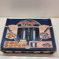 Top view of vintage Ataco Magic 4 in 1 Cookie Maker box showing the product uses and images of cookies, noodles, and cake decoration.