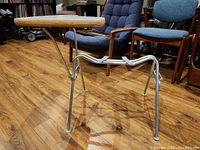 Side view of 1960s Herman Miller student desk showing chrome tubular legs and plywood surface