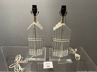 Two lamps without shades shown side by side on clear acrylic surface