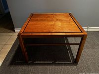 Top-down view of mid century modern walnut table showing wood grain and design details.