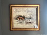 Front view of the framed oil painting showing a rural landscape with cottages and a bare tree.