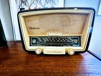 Front view of Normende Elektra vintage tube radio showing woven speaker grill, control knobs, and tuning display.