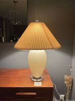 Full view of the vintage mid century modern table lamp showing the ceramic body, pleated lamp shade, and Lucite finial on top.