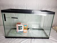 Full view of the empty glass aquarium tank with black trim and AquaClear filter box inside.