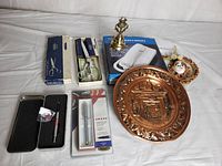 Full lot shown: scissors, bell, copper plate, ornament, phone in box, pen set