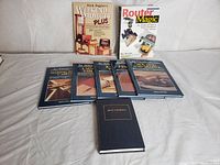 All nine books in the collection arranged in two rows on a white sheet, showing titles and covers mostly by Nick Engler and one black hardcover book.