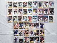 Overview photo showing 45 hockey cards laid out on a flat surface in plastic sleeves.