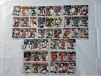 Top view of hockey cards arranged in rows on a white surface, showing all 45 cards in plastic sleeves.