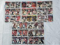 Photo showing hockey cards arranged in rows on a white surface, highlighting different NHL players and team logos from 1990-1992.
