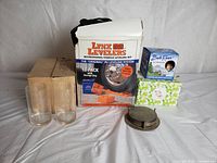 Lot showing all items including glasses, glass holders, gift mugs, Lynx Levelers kit box and leveling blocks, and coasters.