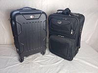 Front view of two travel suitcases side by side, one hard shell and one soft fabric case.