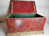 Closed view of vintage wooden box with red exterior and green interior edges visible