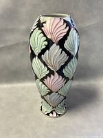 Front view of the 14-inch ceramic vase showing colorful leaf pattern on black background.