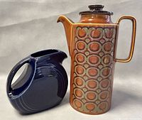 Hornsea Heirloom pattern coffee pot next to the Fiesta cobalt blue disc pitcher showing both items side by side.