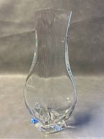 Front view of Baccarat crystal vase showing its clear curved form and square base.