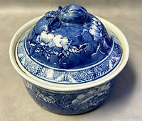 Blue and white porcelain covered tea caddy, showing floral design and sculpted lid knob