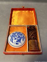 View of the carved Shoushan stone stamp and the porcelain red wax holder inside the lined box.