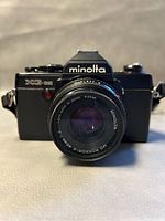 Front view of Minolta XG-SE camera with MD Rokkor-X 45mm f/2 lens attached, showing lens glass and markings.