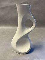Modernist SGRAFO German white porcelain vase showing front sculptural curved form and circular cutout