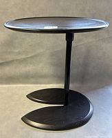 Front left perspective showing entire elliptical tabletop, central support column, and double-leaf base.