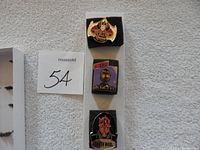 Three Star Wars pins displayed vertically on white foam backing. Top pin is gold Star Wars logo, middle shows C-3PO, bottom depicts Darth Maul.