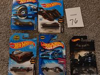 Five Hot Wheels die cast cars in original packaging. Four packages are clearly visible featuring Batman and Batmobile themes; fifth package partially visible.