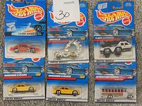 Seven Hot Wheels diecast toy cars in original packaging showing different series and models