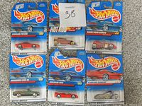 Six Hot Wheels die cast cars in original packaging arranged in two rows of three. Models include Ferrari F355, Ferrari F50, Hot Rod, Gran Devo Series, and Mercedes 500 SL. Cards are blue with Hot Wheels logo and some feature Ferrari branding.