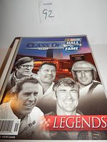 Cover of the 2011 NASCAR Hall of Fame Class of Legends book with images of legendary drivers.