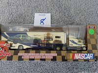 Photo showing packaged Racing Champions 10th Anniversary die cast transporter truck with the number 26 NASCAR car on trailer.