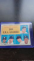 Front view of 1961 Topps baseball card showing Don Drysdale and other National League ERA leaders from 1960, in protective plastic sleeve.