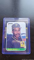 Photo of 1986 Donruss Barry Bonds rookie baseball card in protective case showing portrait of Bonds in Pirates uniform holding bat.