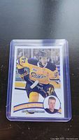 Photo of a Connor McDavid Erie Otters hockey card in protective plastic sleeve showing action shot and inset portrait.