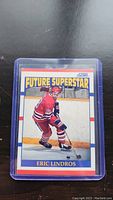 Eric Lindros Future Superstar rookie hockey card in plastic sleeve on black surface.