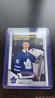 Photo of Joseph Woll rookie card in protective case showing player in Toronto Maple Leafs uniform.