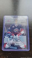 Photo of signed Marc Denis 2002 Single Shots hockey card in protective case.