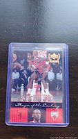 Photo of Michael Jordan Chicago Bulls basketball card in protective sleeve showing front with action and portrait images.