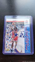 Close-up photo of 1993 NBA Finals Michael Jordan basketball trading card in protective plastic case showing the image of Jordan shooting a jump shot during Game 1 of the Finals.
