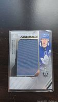 Front side of Mitch Marner Banner Year jersey card with large blue jersey piece and image of player in Toronto Maple Leafs uniform.