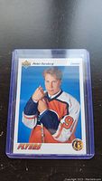 Photo of Peter Forsberg rookie hockey card in a protective hard plastic case on a dark surface.