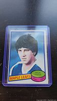 Photo of the Rick Vaive rookie hockey card in a plastic protective sleeve showing portrait and Maple Leafs team name.