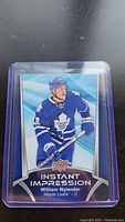 Photo of William Nylander rookie hockey card showing player in blue Maple Leafs jersey, card in protective plastic sleeve.