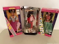 Three Barbie dolls in original boxes: French Barbie, Busy Gal Barbie (box damaged), Polynesian Barbie.