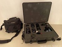 Overview of all camera lenses placed in a grey hard case with foam compartments, next to a Canon camera shoulder bag.