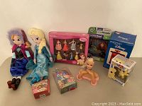 Full lot overview including plush dolls, boxed figurine sets, toys, and bust doll